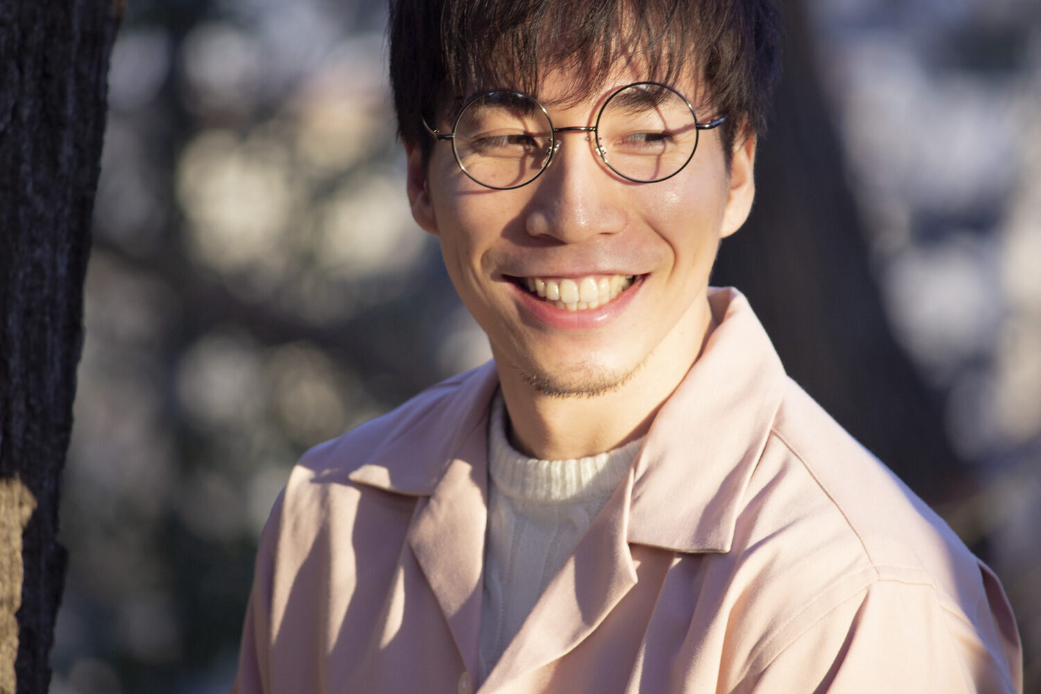 屋外で笑う松坂慎治